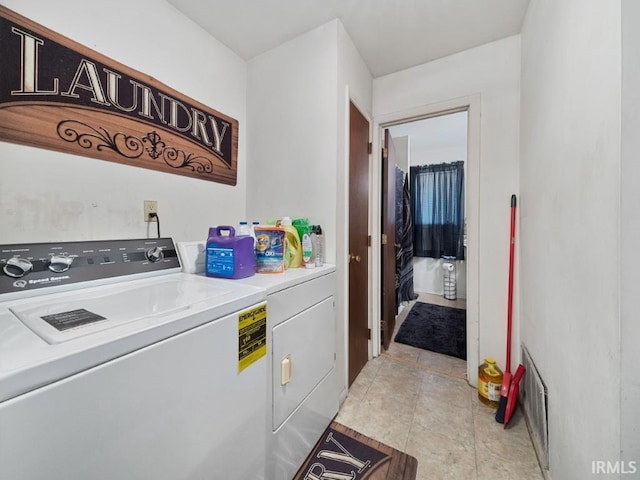 clothes washing area featuring washing machine and dryer and light tile patterned floors