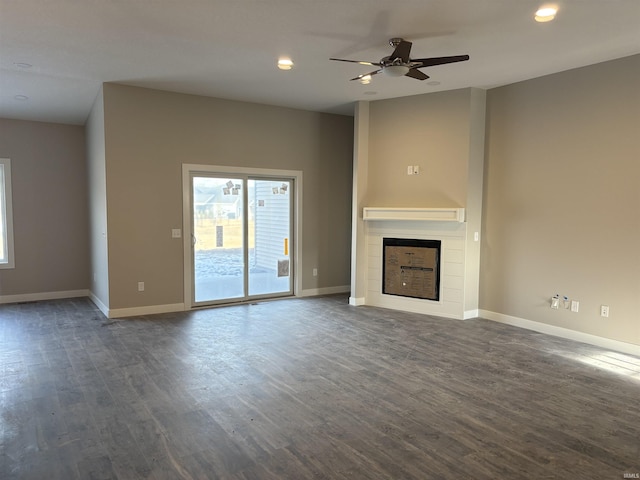 unfurnished living room featuring dark hardwood / wood-style flooring and ceiling fan