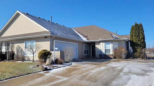 view of front of house with an attached garage, driveway, a shingled roof, and brick siding