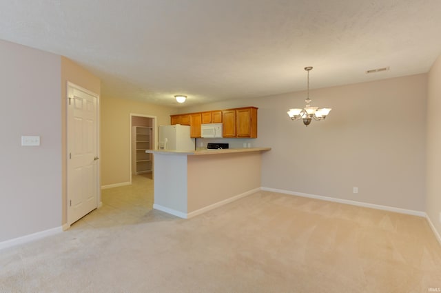 kitchen featuring light carpet, hanging light fixtures, white appliances, and a chandelier