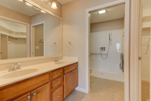 bathroom featuring vanity, tile patterned flooring, and a shower