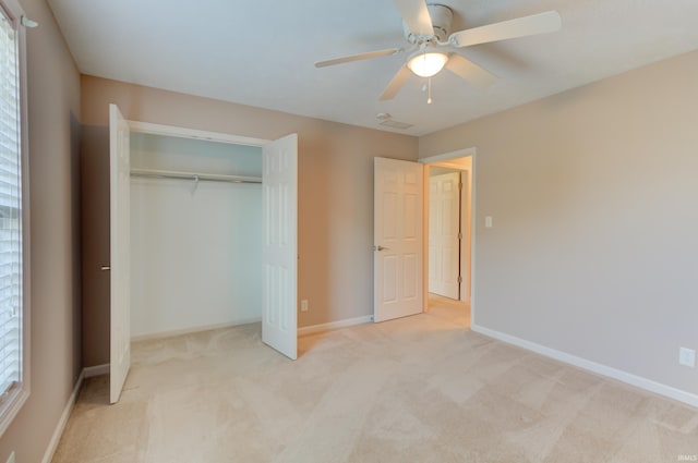 unfurnished bedroom featuring ceiling fan, a closet, and light carpet