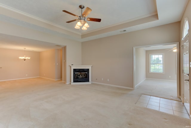 unfurnished living room featuring ornamental molding, a raised ceiling, ceiling fan with notable chandelier, and light carpet