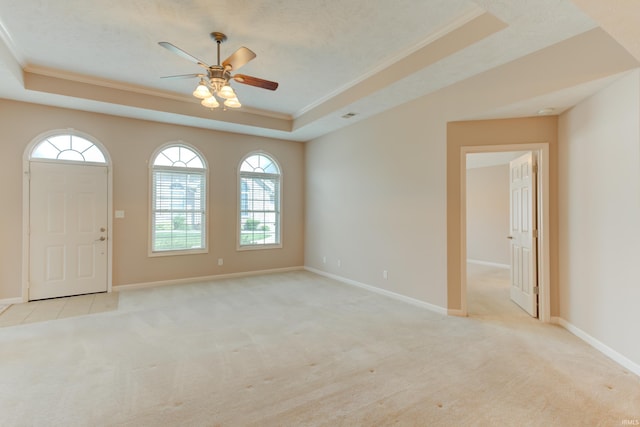 carpeted spare room featuring crown molding, a tray ceiling, and a textured ceiling