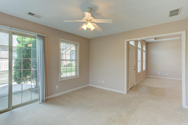carpeted empty room featuring plenty of natural light and ceiling fan