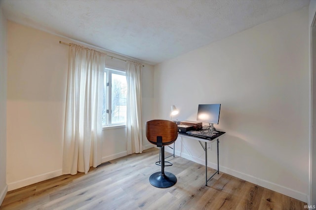 office area featuring a textured ceiling and light wood-type flooring