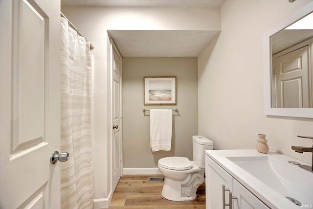 bathroom featuring vanity, toilet, and hardwood / wood-style floors