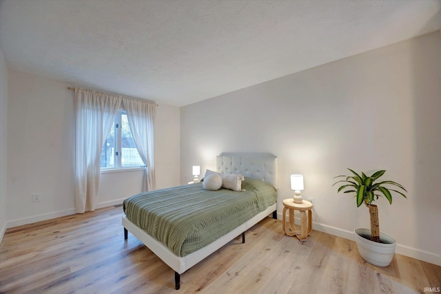 bedroom featuring light hardwood / wood-style flooring and a textured ceiling