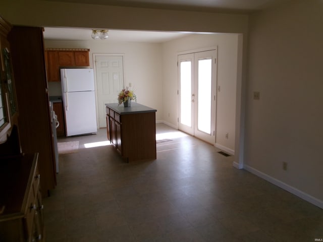 kitchen featuring french doors, a kitchen island, and white fridge