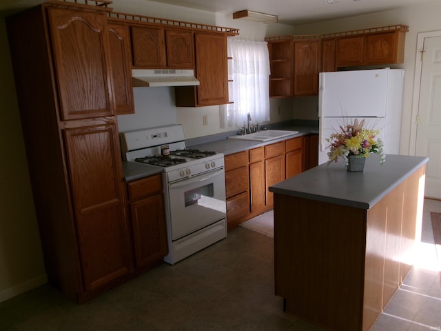 kitchen featuring sink, white appliances, and a center island