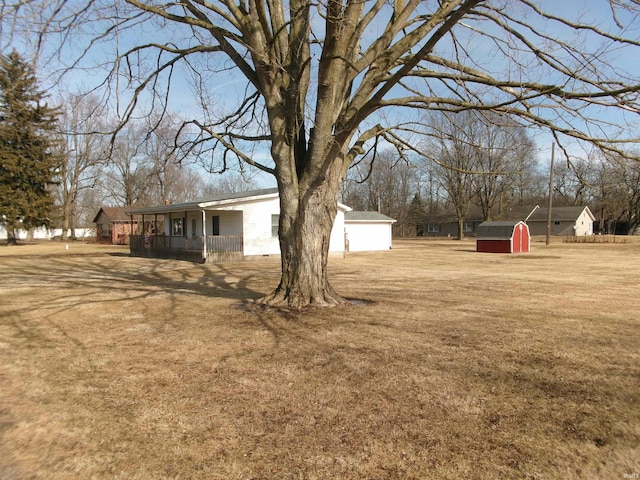 view of yard featuring covered porch and a shed