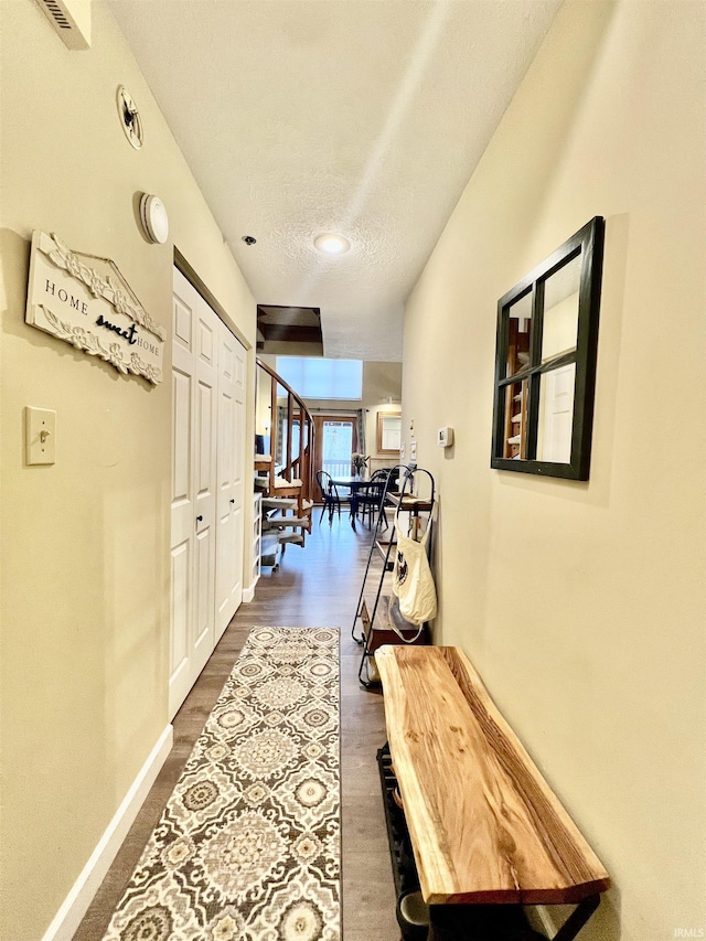 hallway featuring dark hardwood / wood-style flooring and a textured ceiling