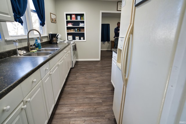 kitchen featuring dark hardwood / wood-style floors, sink, white cabinets, and white appliances