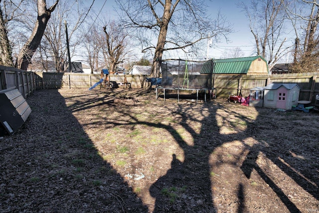 view of yard with a playground and a trampoline