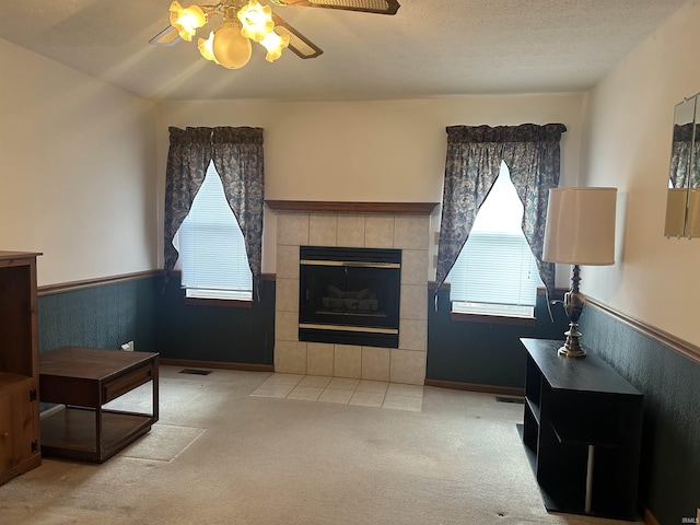 living room with a healthy amount of sunlight, a fireplace, light carpet, and a textured ceiling