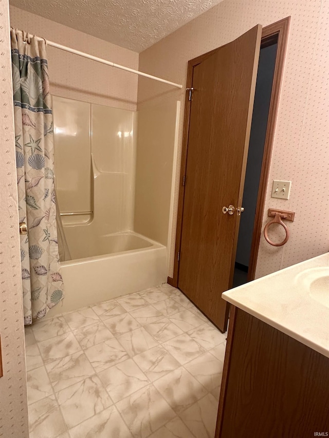 bathroom featuring vanity, shower / bathtub combination with curtain, and a textured ceiling