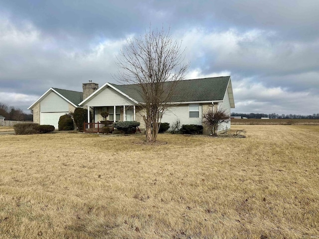 ranch-style home featuring a garage, covered porch, and a front lawn