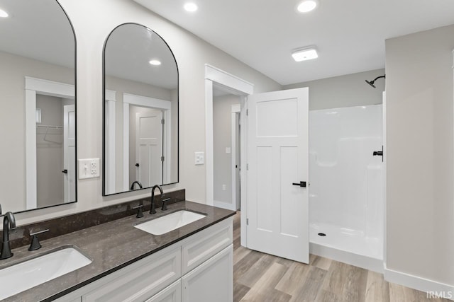 bathroom with vanity, hardwood / wood-style flooring, and a shower