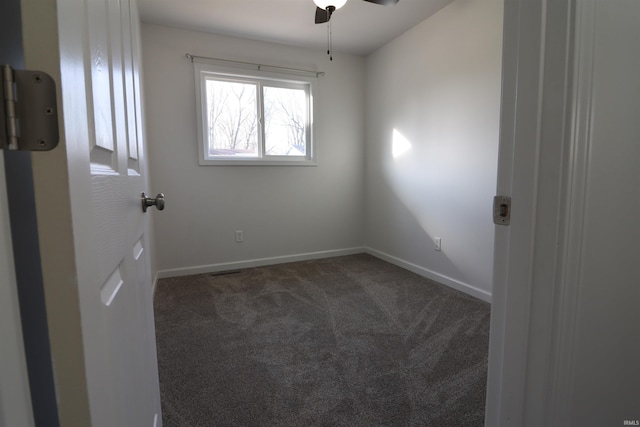 unfurnished room with dark carpet and ceiling fan