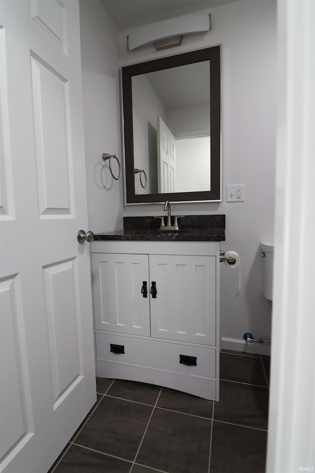 bathroom featuring vanity, tile patterned floors, and toilet