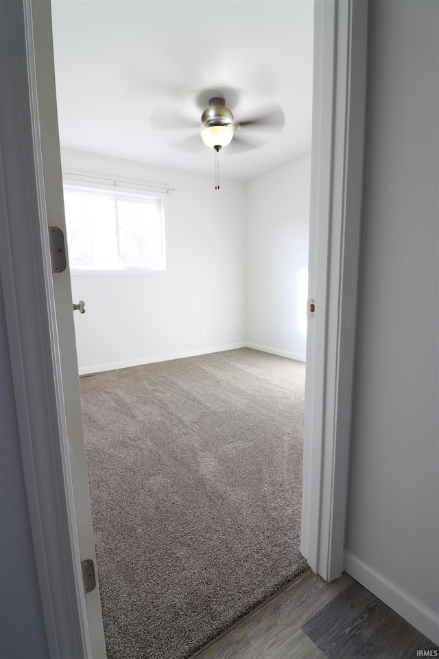 carpeted spare room featuring ceiling fan