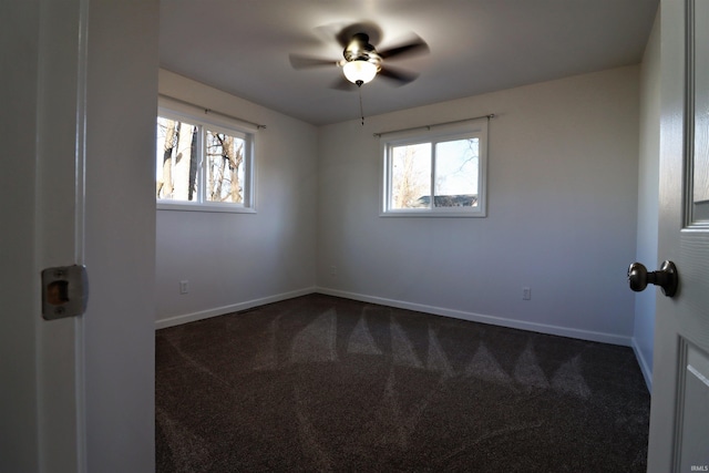 carpeted spare room featuring plenty of natural light and ceiling fan