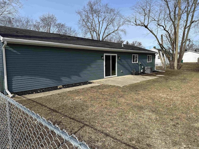 back of property with central AC, a lawn, and a patio area