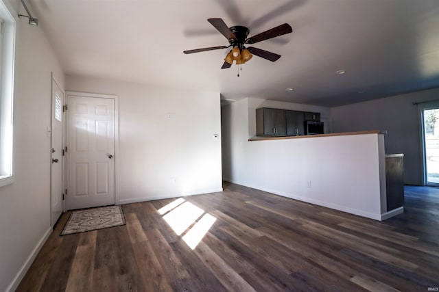 unfurnished living room featuring dark hardwood / wood-style floors and ceiling fan