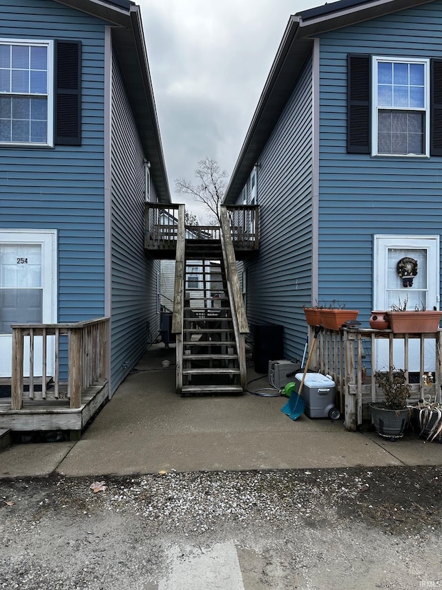 view of side of property featuring a wooden deck and a patio area