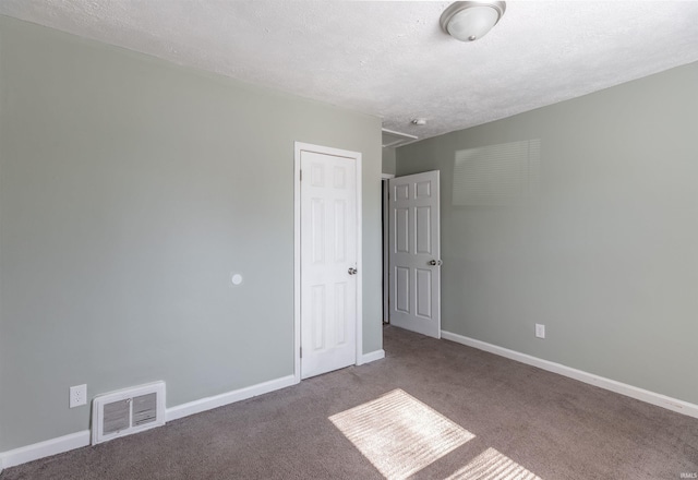 carpeted spare room featuring a textured ceiling