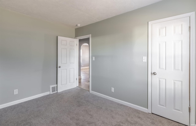 unfurnished bedroom featuring carpet floors and a textured ceiling