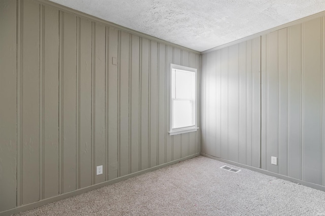 carpeted spare room featuring a textured ceiling