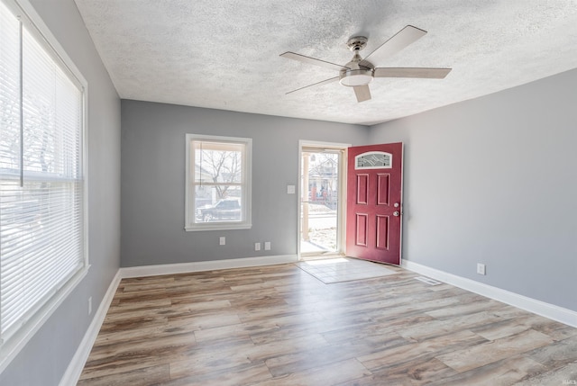 foyer featuring a textured ceiling, light hardwood / wood-style flooring, and ceiling fan