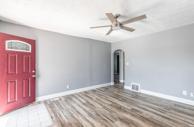 entrance foyer with ceiling fan, light hardwood / wood-style flooring, and a textured ceiling