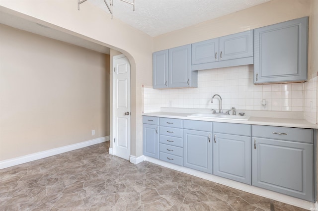 kitchen with sink, backsplash, and a textured ceiling