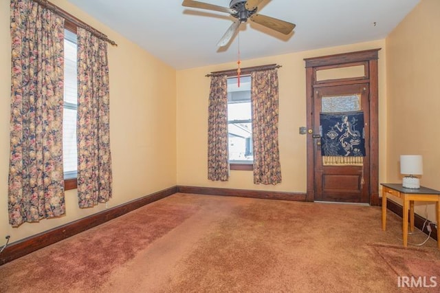 carpeted entryway featuring ceiling fan