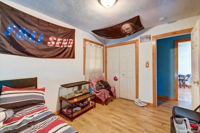 bedroom with hardwood / wood-style floors, a closet, and a textured ceiling