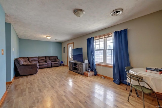 living room with light hardwood / wood-style flooring and a textured ceiling