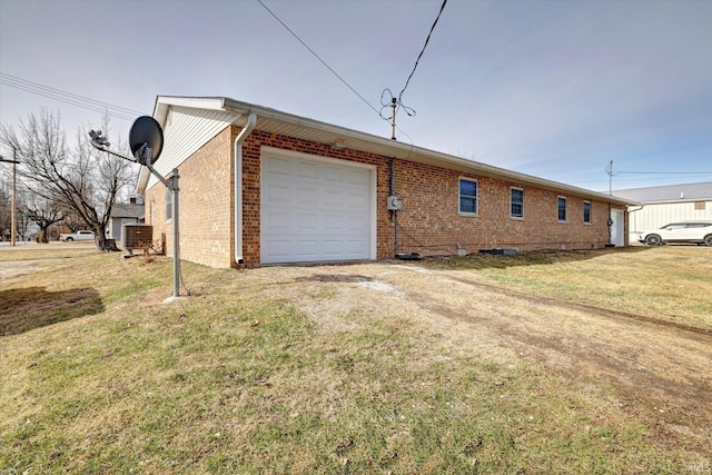 view of side of property featuring a garage and a lawn