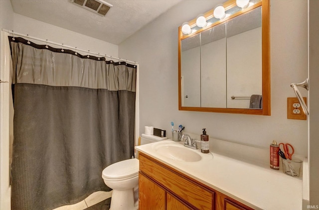 bathroom with vanity, a textured ceiling, toilet, and walk in shower