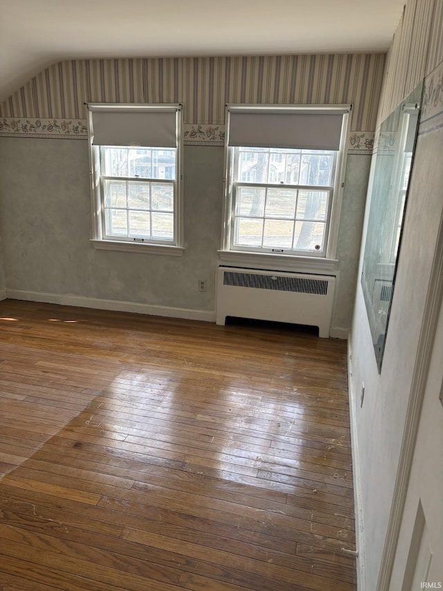 empty room featuring radiator and wood-type flooring