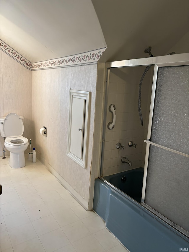 bathroom with bath / shower combo with glass door and toilet