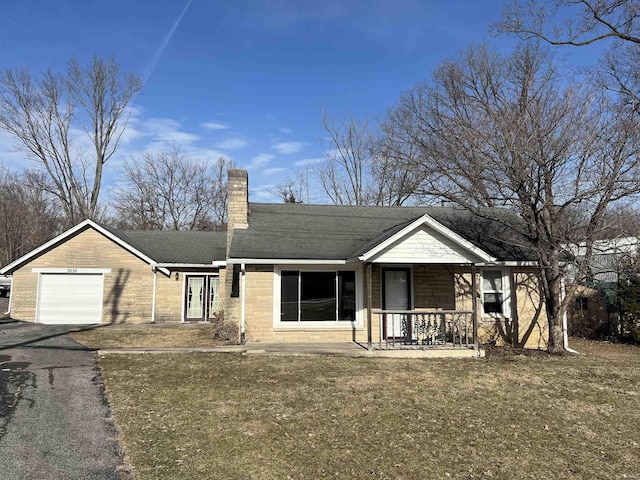 view of front of house with a garage, covered porch, and a front lawn