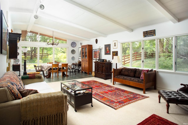 interior space with a healthy amount of sunlight, vaulted ceiling with beams, and a chandelier