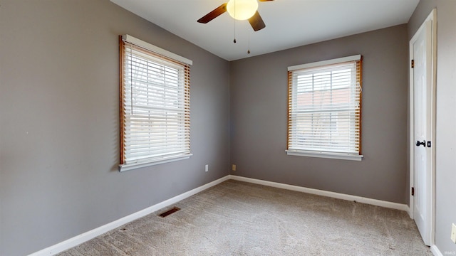 unfurnished room with ceiling fan and carpet