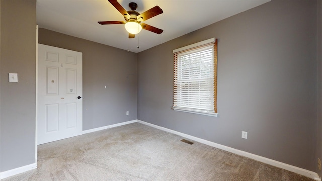 spare room with ceiling fan and light colored carpet