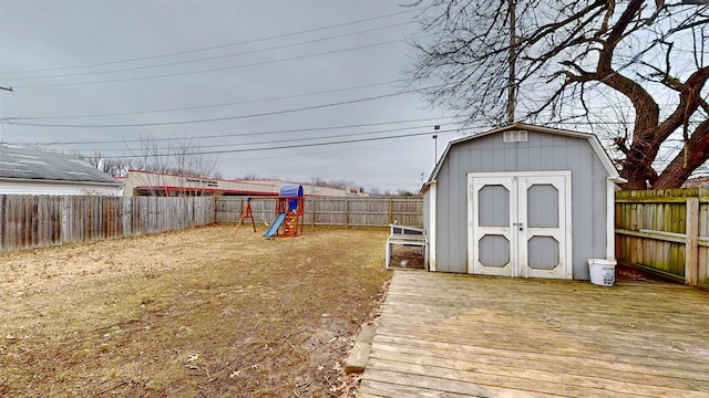 view of yard with a playground, a deck, and a shed