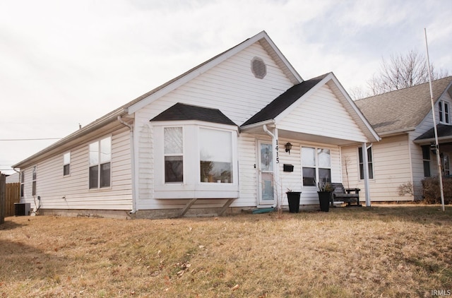 back of house with cooling unit and a lawn