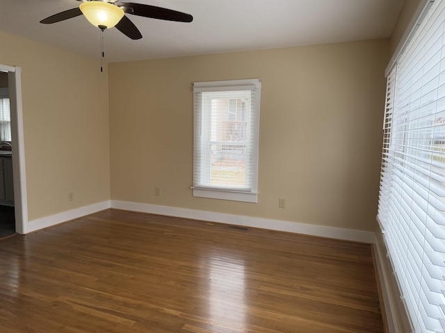 empty room with dark wood-type flooring and ceiling fan