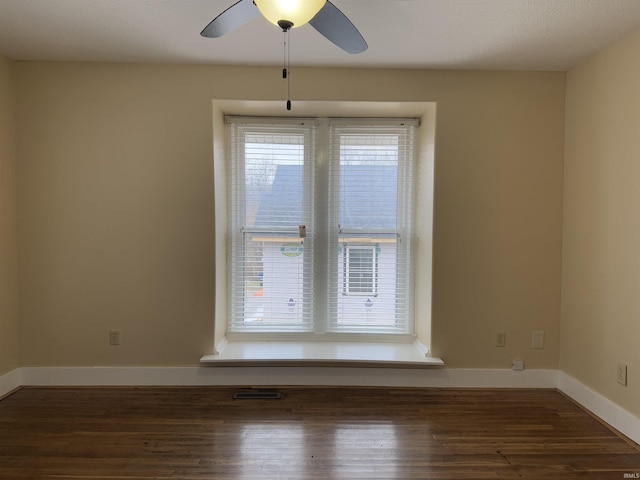 empty room featuring dark hardwood / wood-style flooring and ceiling fan